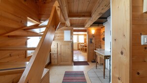 A wooden interior with a staircase leading to a dining area. - Holiday home Nüssli for 6 people with fantastic mountain views (Wildhaus)