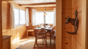 A wooden interior with a dining area, wooden walls, and a mounted animal head decoration. - Holiday home Nüssli for 6 people with fantastic mountain views (Wildhaus)