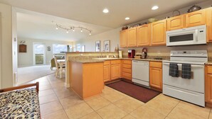 A modern kitchen with wooden cabinets, a white stove, and a microwave.
