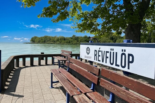 Una panchina e un cartello con la scritta 'REVFÜLÖP' su una passeggiata sul lungomare.