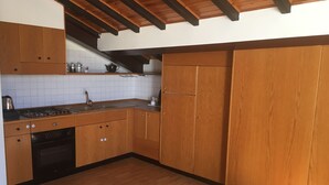 Une cuisine avec des meubles de rangement en bois, une cuisinière et un évier.