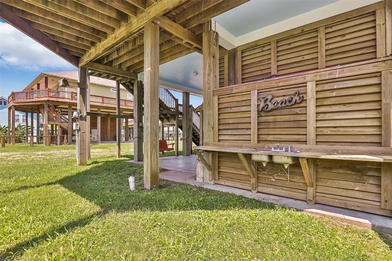 A wooden structure with a sign reading 'Beach' and a bench outside.