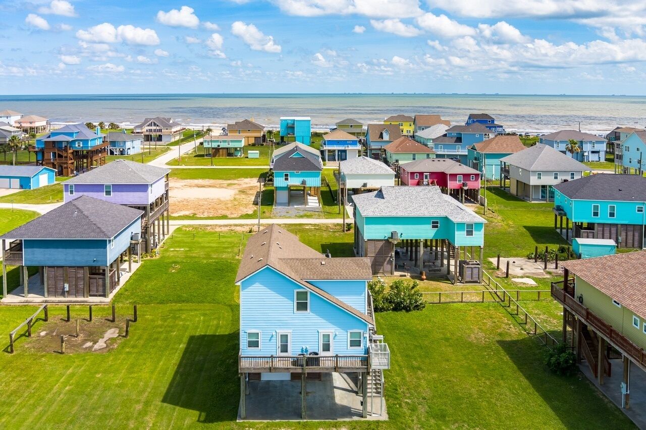 A coastal residential area with houses featuring balconies and waterfront views.
