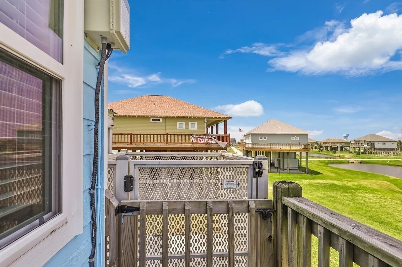 A residential area with houses, a wooden deck, and a clear sky.