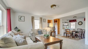 A living room with a sofa, coffee table, and dining area with chairs and a table. - Lakefront Maine House ~ 4 Mi to Colby College (Oakland)