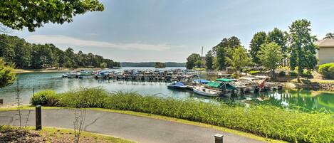 A marina with boats docked, surrounded by greenery and trees.