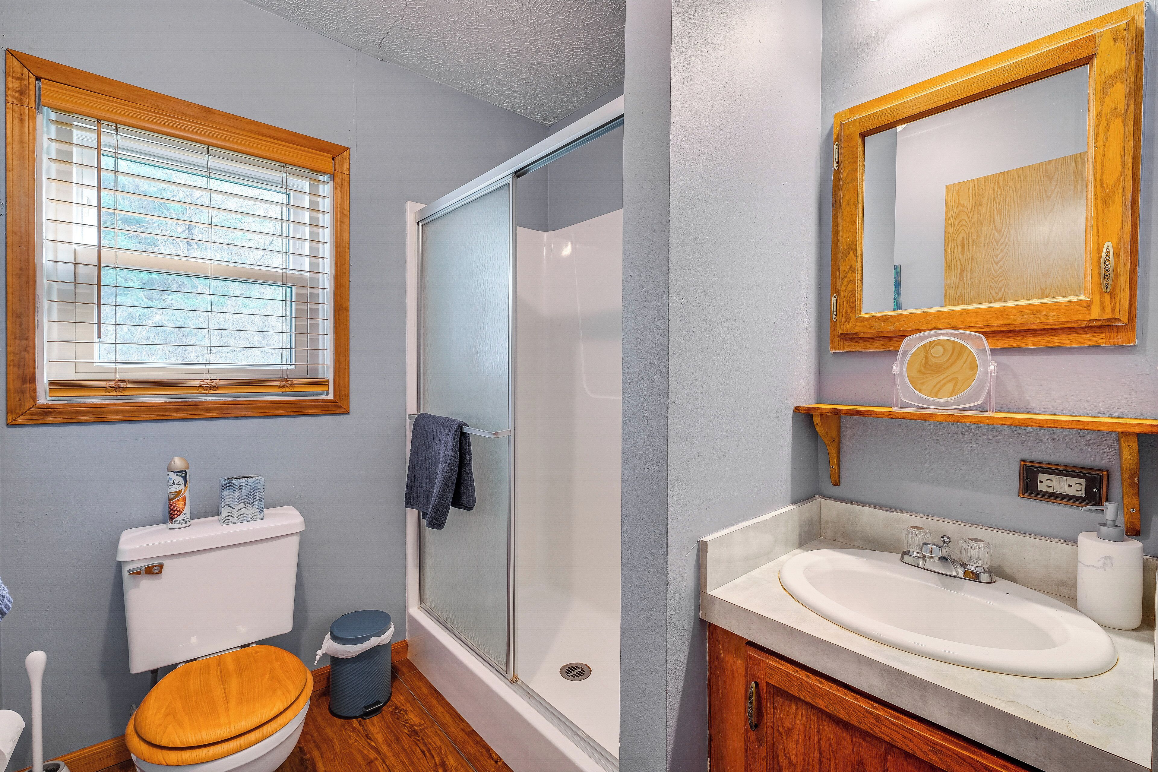 Une salle de bain équipée de toilettes, d’une douche, d’un lavabo et d’un miroir.