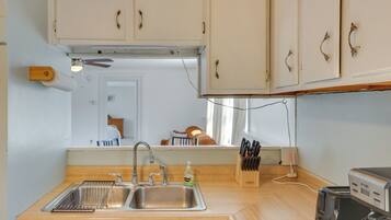 A kitchen with a sink, a coffee maker, and wooden cabinets.