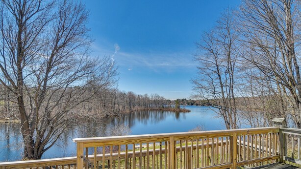 A wooden deck overlooking a calm lake with bare trees and a clear sky. - Lakefront Oakland Vacation Rental w/ Dock + Views! (Oakland)