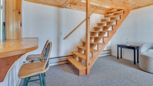 A wooden staircase in a room with a wooden table and chairs. - Lakefront Oakland Vacation Rental w/ Dock + Views! (Oakland)