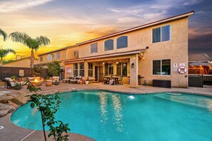 A house with a swimming pool, outdoor furniture, and a patio area.