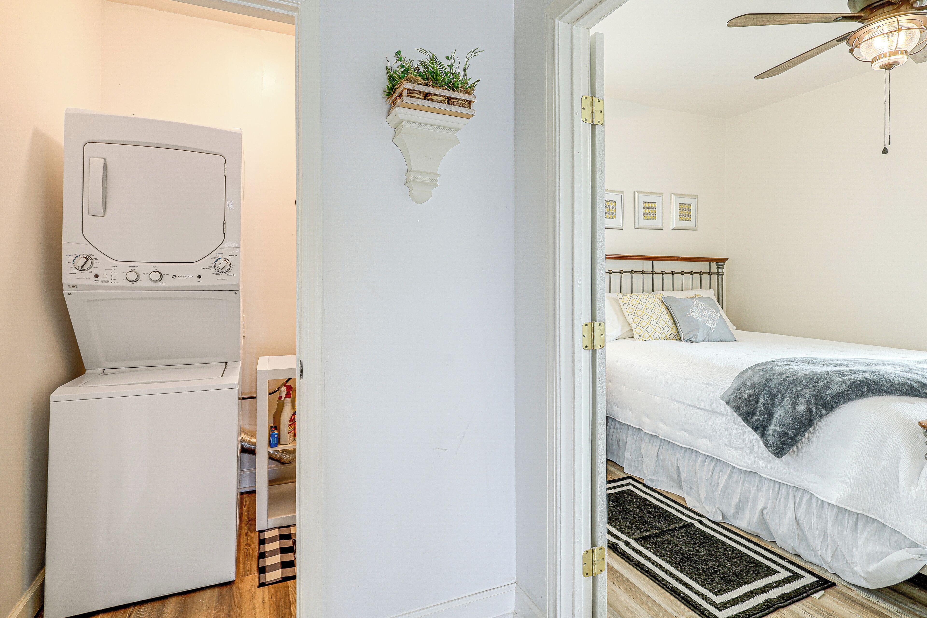 Quarto com cama, planta na parede e ventoinha no teto.