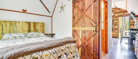 A bedroom with a wooden bed, a sliding barn door, and a star decoration on the wall.