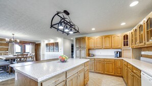 A spacious kitchen with wooden cabinets, a granite countertop, and a central island.
