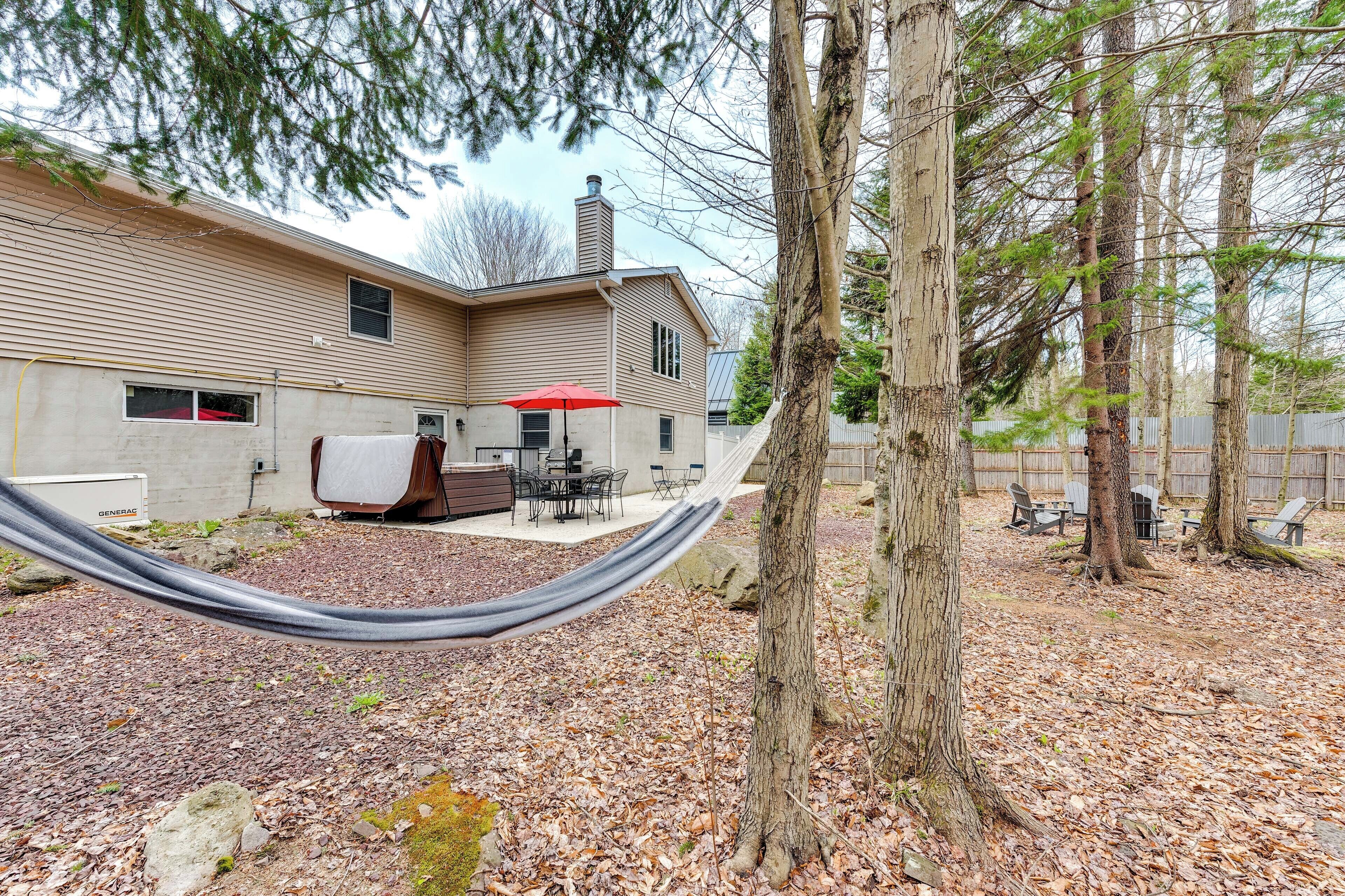 A residential property with a covered patio, outdoor furniture, and a hammock.