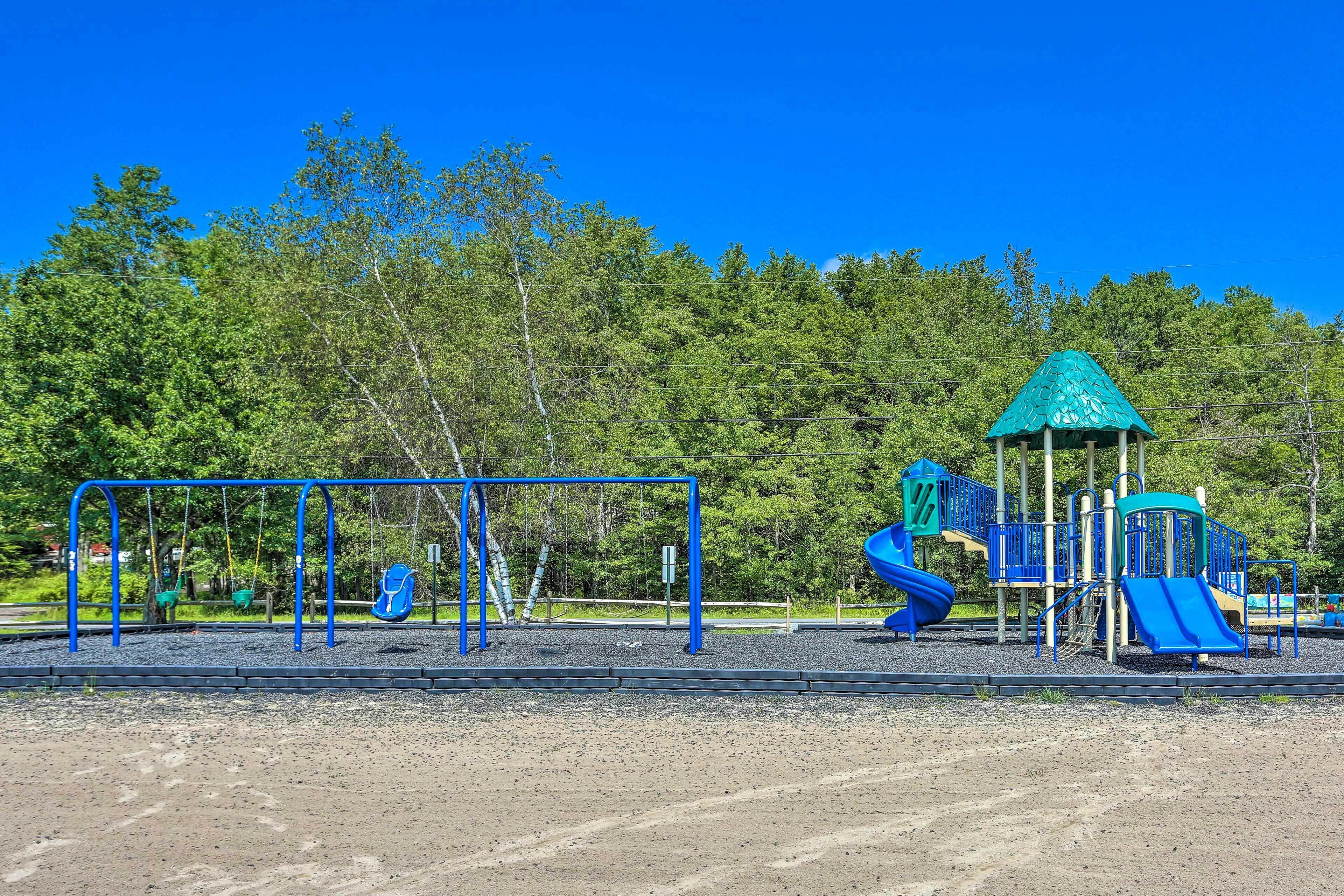 Un parque infantil con columpios, toboganes y una estructura para escalar.