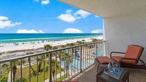 Un balcon avec vue sur une plage et une piscine.