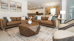 A modern living room with a sectional sofa, a wooden coffee table, and a patterned rug. - Stylish 6BD/5BA Pet-Friendly Villa 346 (Davenport)