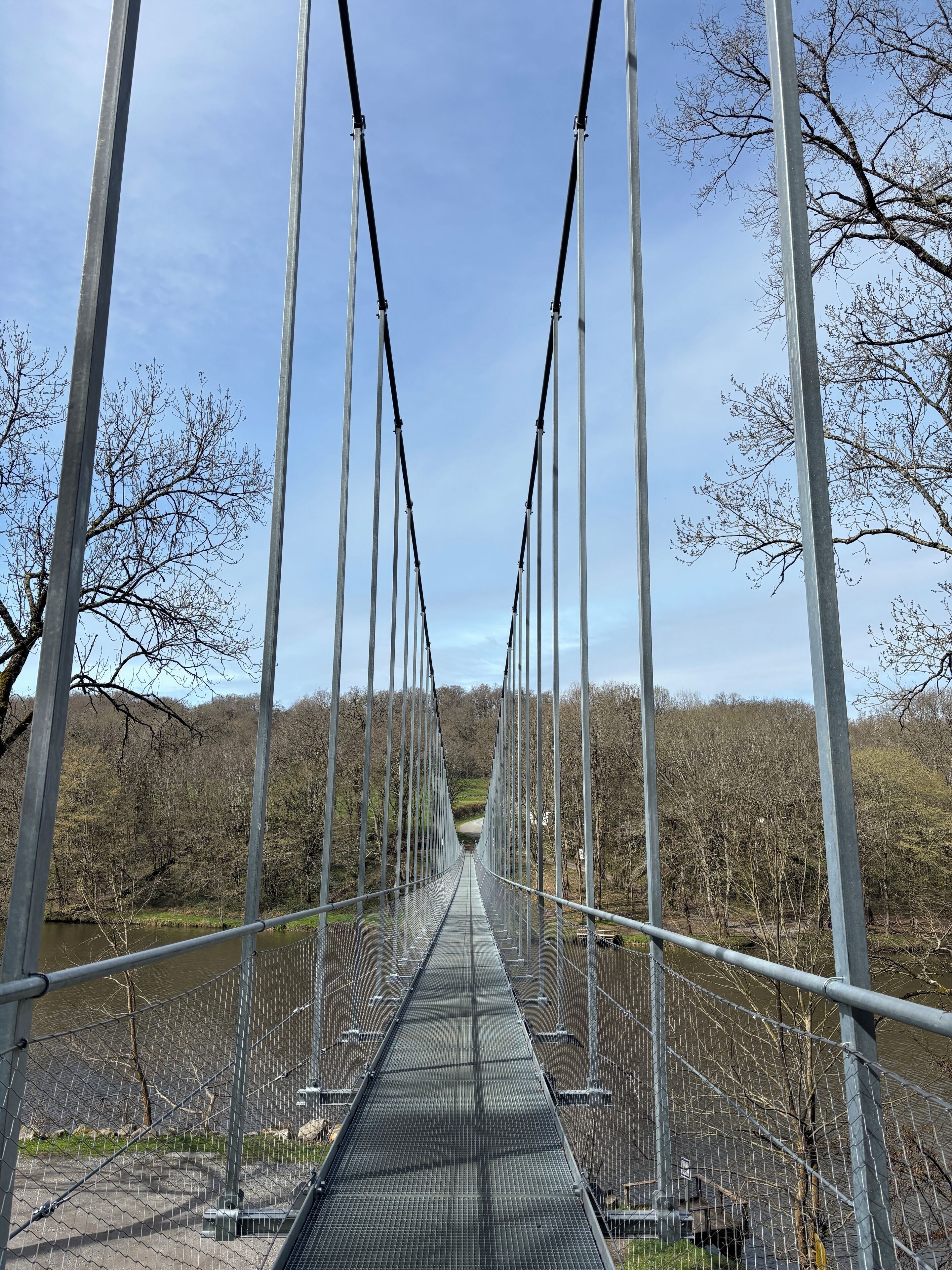 Eine Hängebrücke mit Metallseilen und einem Metallbelag.