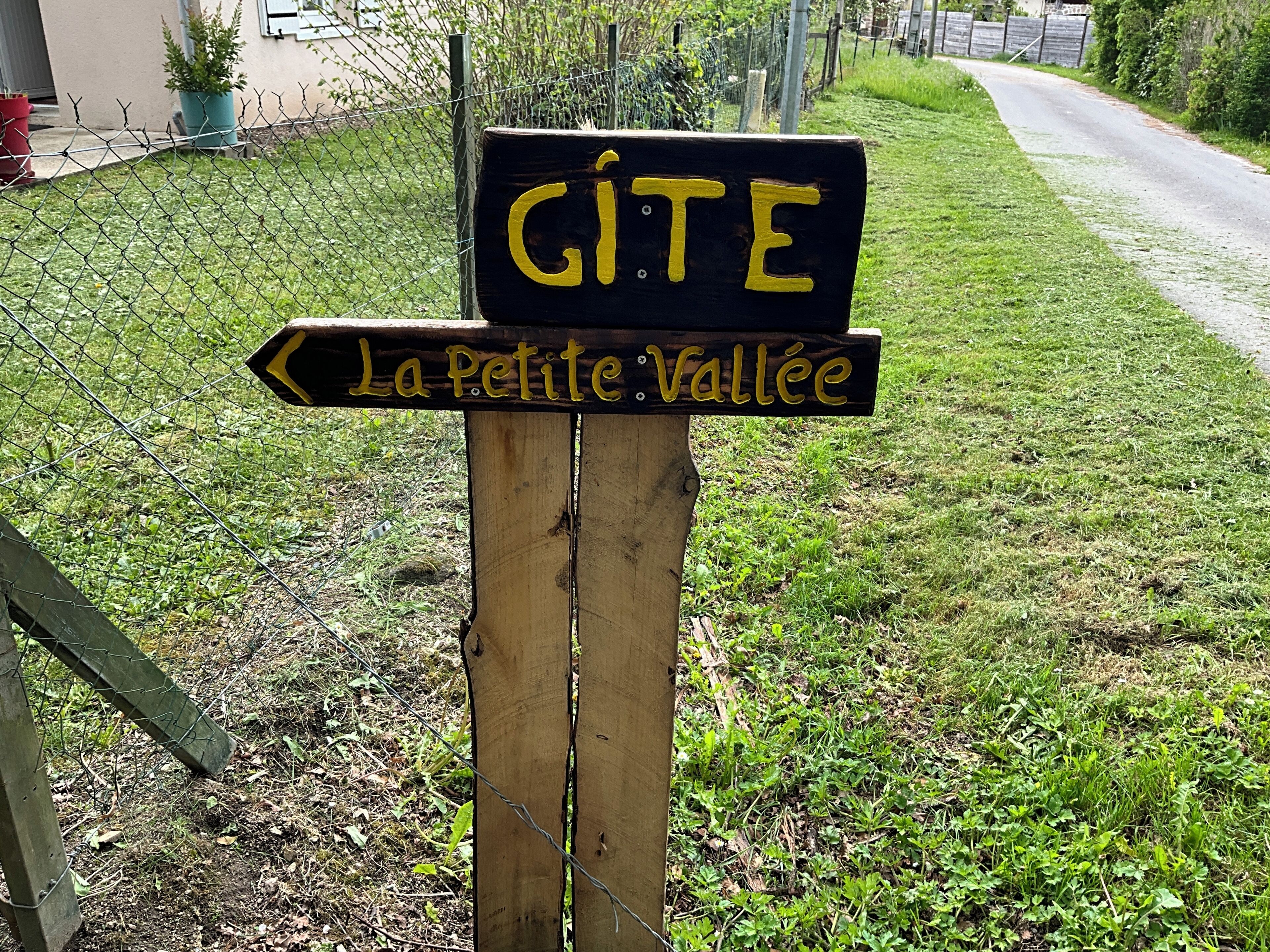 Un cartello in legno con indicazioni per 'GITE' e 'La Petite Vallée'.