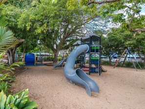 Une aire de jeux avec un toboggan et des structures d’escalade.