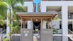 A modern building with a covered entrance labeled '35-41' and 'Terraces on Gattton.' - The Loft—Trendy Coastal Charm with Pool (Cairns North)