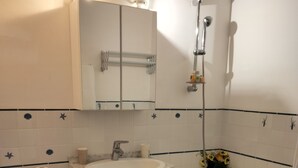 A compact bathroom with a toilet, sink, and bathtub.