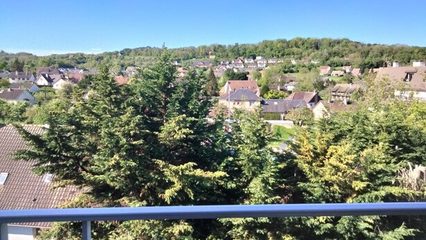 A residential area with houses, trees, and a clear sky.