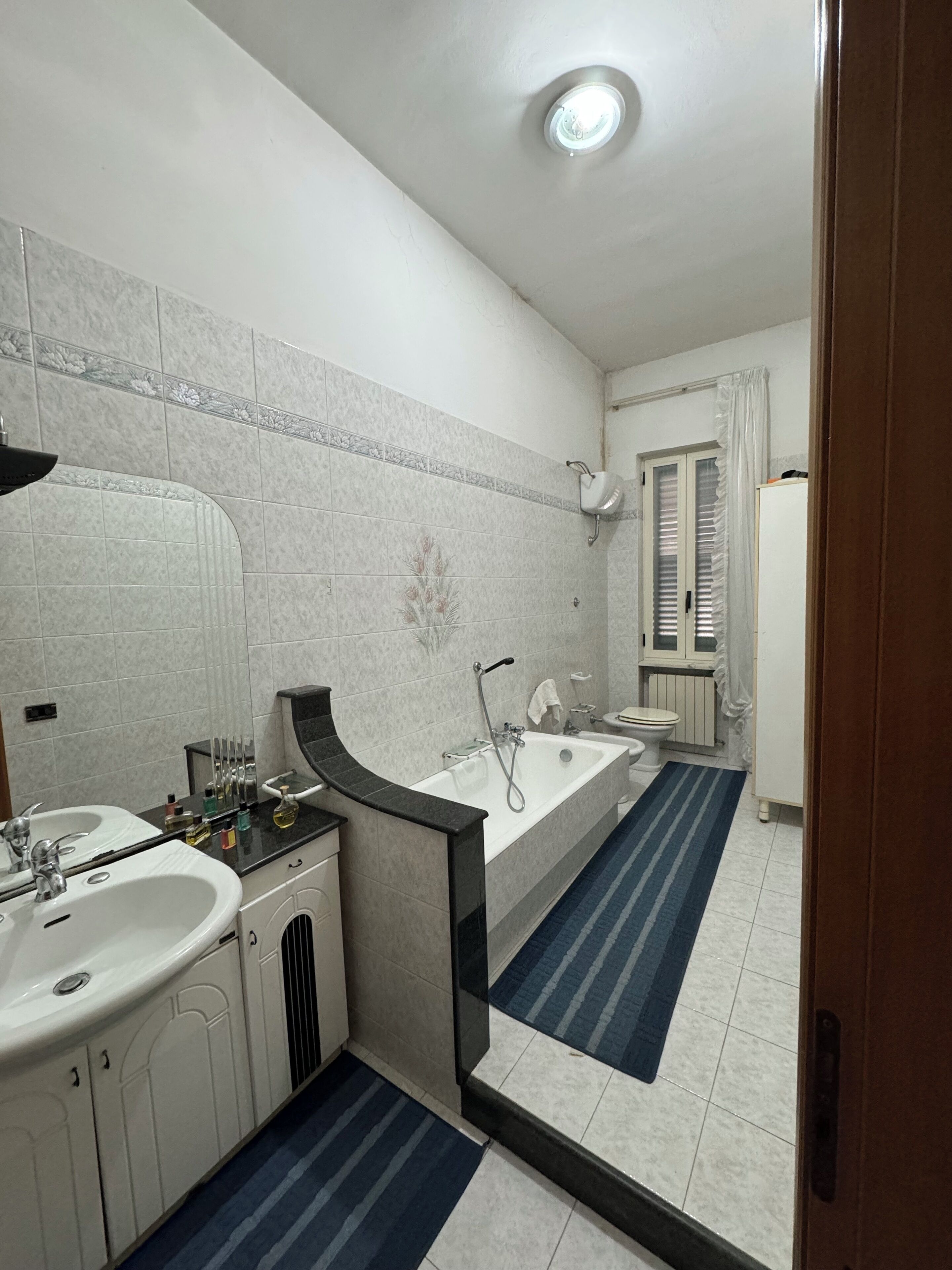 Ein Badezimmer mit Waschbecken, Spiegel, Waschtisch, Badewanne und Toilette.