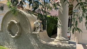 A stone sculpture with a carved design, a small fountain, and a gate in a courtyard. - Beautiful and charming condo in Woodhaven Country Club! Recently updated (Palm Desert)