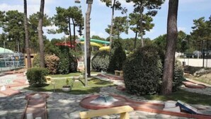 A park with a water feature, benches, and a playground area.