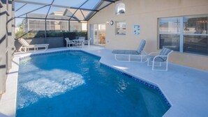 Ein Pool mit Glasumrandung, Liegestühlen und einer Terrassenanlage.