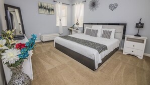A bedroom with a large bed, bedside tables, a dresser, and a mirror. - The Stirling Luxury Solterra Vacation Home (Davenport)