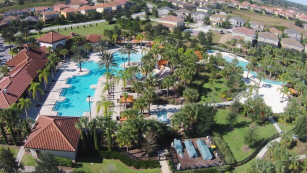 An aerial view of a resort with multiple swimming pools, palm trees, and residential buildings in the background. - The Stirling Luxury Solterra Vacation Home (Davenport)