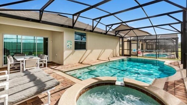 Ein überdachter Außenpool mit Whirlpool, Liegestühlen und einer Terrassenanlage.