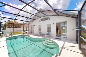A covered outdoor swimming pool with lounge chairs and a glass door entrance. - Len & Arlene's Tuscan Ridge Vacation Home (Davenport)
