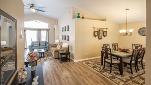 A spacious living room with a dining area, hardwood flooring, and a large mirror. - Rafael's Solana Resort Vacation Home (Davenport)