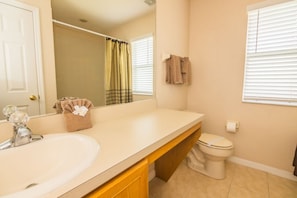 A bathroom with a sink, toilet, and a mirror. - Lynval's Regal Palms Resort Townhome (Davenport)