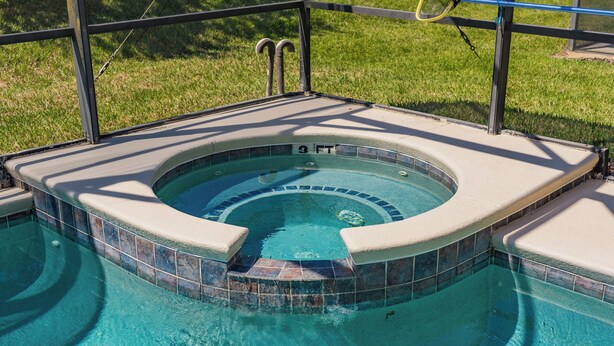 Un bain à remous doté d’un bord carrelé et d’un diamètre de 4 pieds.