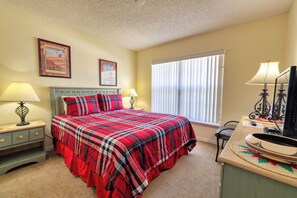A bedroom with a bed, two bedside tables with lamps, a dresser, a window with blinds, and two framed pictures on the wall. - Arler House - Amazing 4 Bed 3 Bath - Private Pool (Clermont)