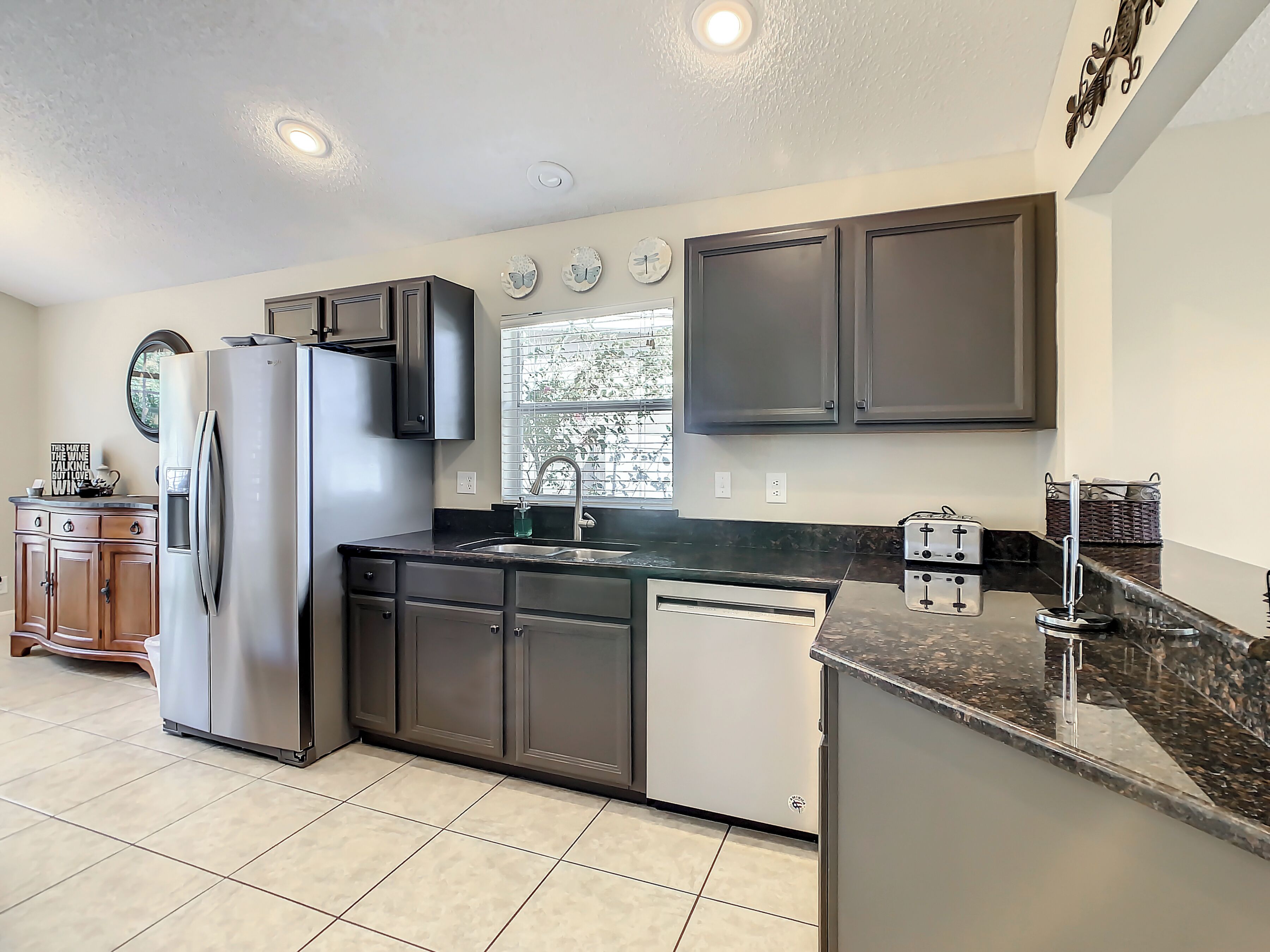 A modern kitchen with a stainless steel refrigerator, a dishwasher, a stove, and a sink.