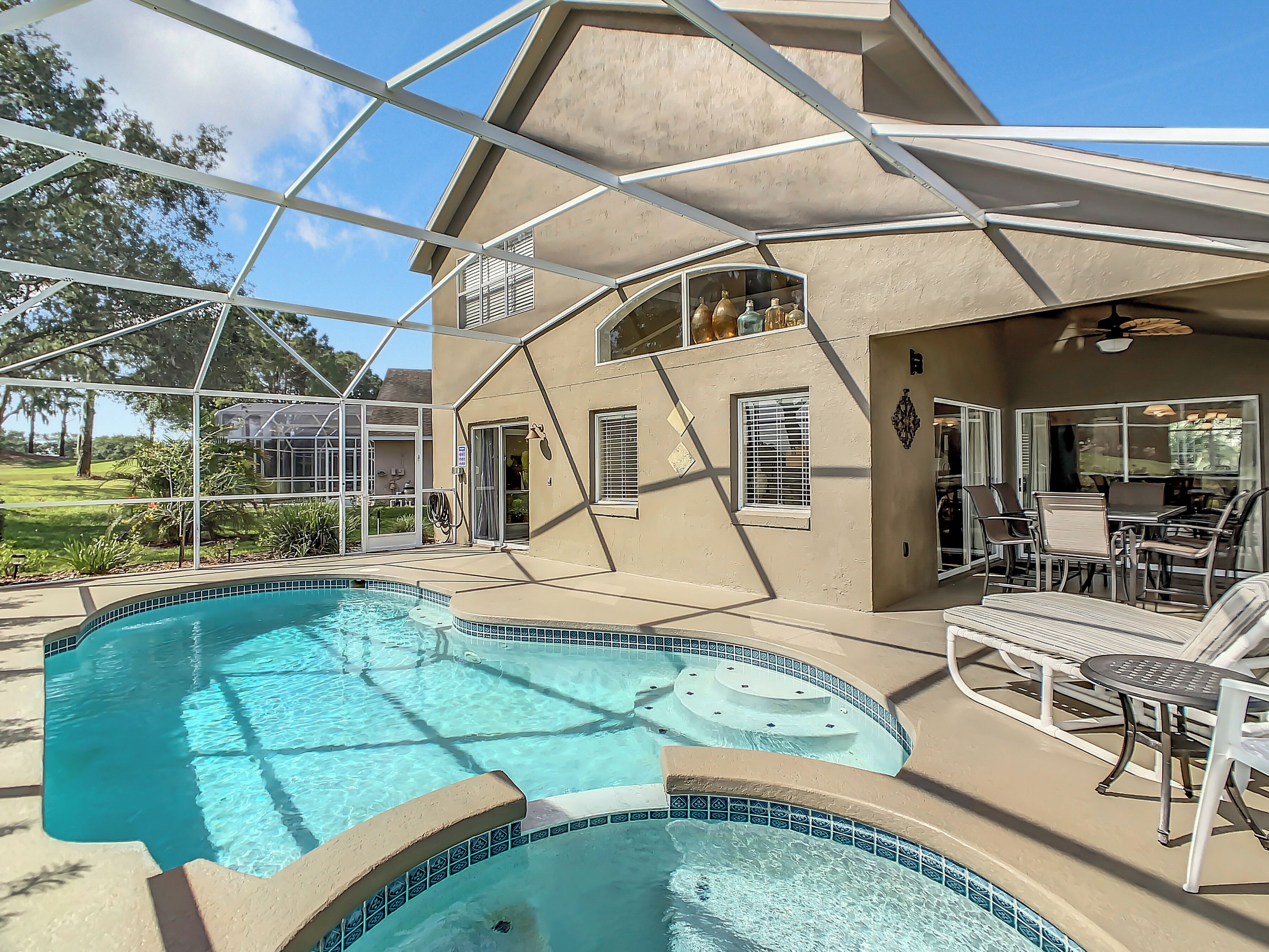 A house with a swimming pool, outdoor seating, and a covered patio.
