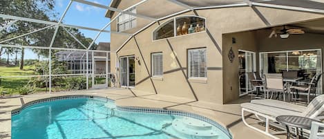 A house with a swimming pool, outdoor seating, and a covered patio.