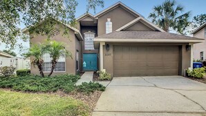 A residential house with a garage, a front door, and a driveway.