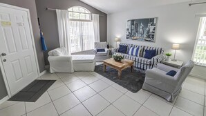 Een woonkamer met een bank, een salontafel en een schilderij aan de muur.