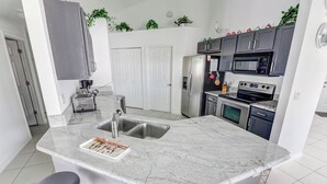 Een moderne keuken met een marmeren eiland, roestvrijstalen apparatuur en een gezellige zithoek.