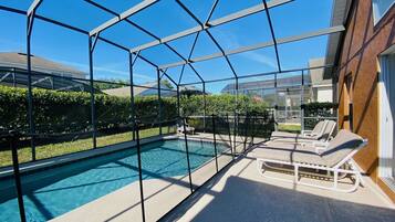 Una piscina exterior cubierta con vistas despejadas del barrio circundante.