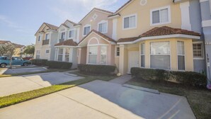 A row of townhouses with a uniform architectural style, featuring pitched roofs and bay windows. - Lake View Townhome Near Disney (Kissimmee)