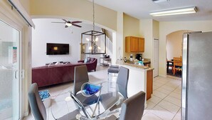 A modern apartment with a living room, dining area, kitchen, and a balcony. - William's Lake Berkley Resort Vacation Home (Kissimmee)