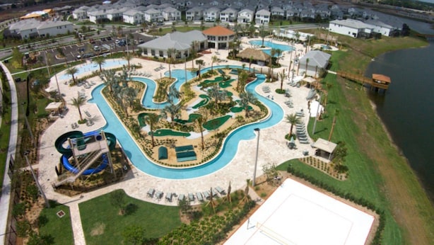 An aerial view of a resort with multiple swimming pools, a water slide, and a large open area for activities. - Brenda's Storey Lake Resort Townhome (Kissimmee)